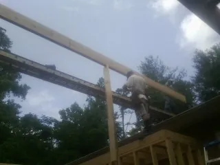Carpenter setting a ridge beam over a new addition frame — Ice Dam Removal by Roofing Brothers in Palisades Park