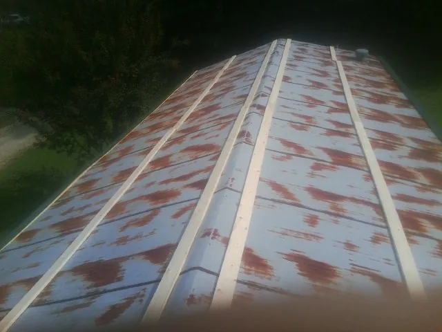 Rusted metal roof panels with new wood purlins before replacement — Storm Damage Roof Repair in Palisades Park by Roofing Brothers