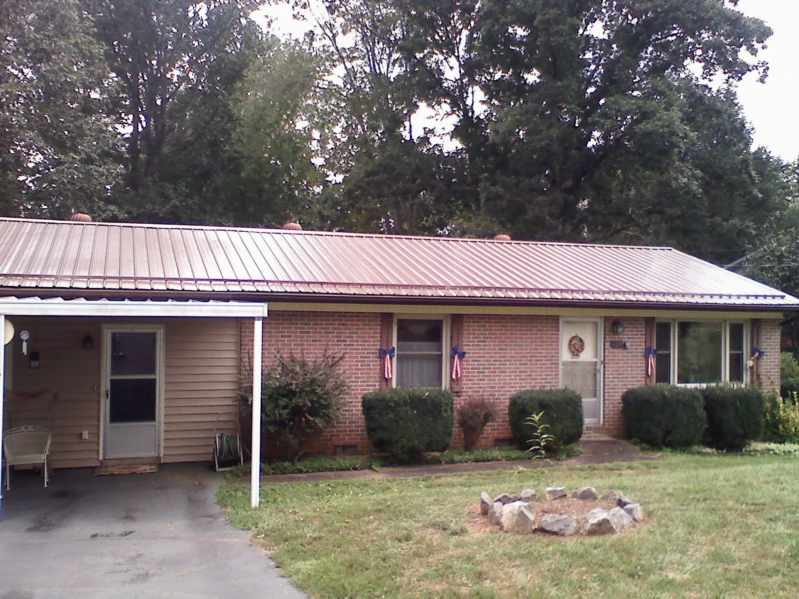 Bronze metal roof and carport on a brick ranch home — Roof Repair work by our crew in Palisades Park